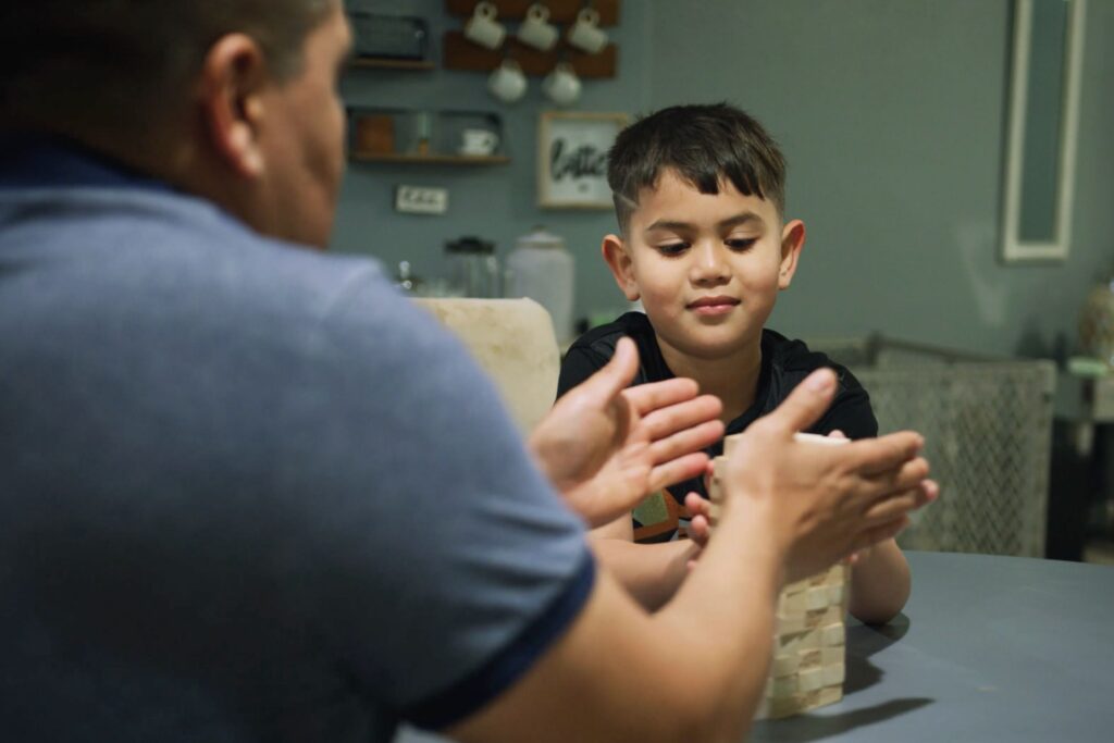 relief foster parent playing jenga at table with foster child